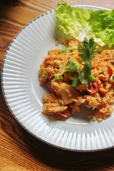 Marul ve kişniş garnitürle servis edilen bir tabakta domuz eti ve kızarmış pilav. Kızarmış pirinç Tayland 'da satılan bir sokak yiyeceğidir..