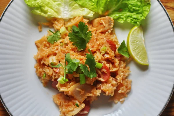 Marul ve kişniş garnitürle servis edilen bir tabakta domuz eti ve kızarmış pilav. Kızarmış pirinç Tayland 'da satılan bir sokak yiyeceğidir..