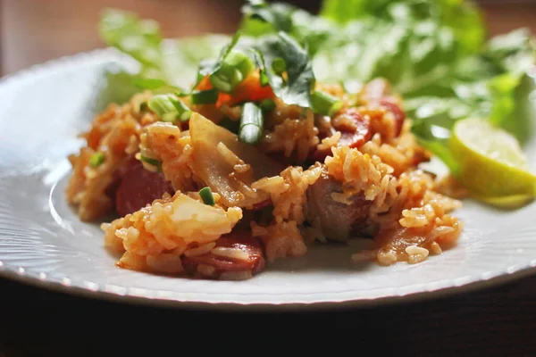 Marul ve kişniş garnitürle servis edilen bir tabakta domuz eti ve kızarmış pilav. Kızarmış pirinç Tayland 'da satılan bir sokak yiyeceğidir..