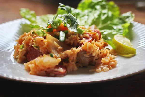 Marul ve kişniş garnitürle servis edilen bir tabakta domuz eti ve kızarmış pilav. Kızarmış pirinç Tayland 'da satılan bir sokak yiyeceğidir..