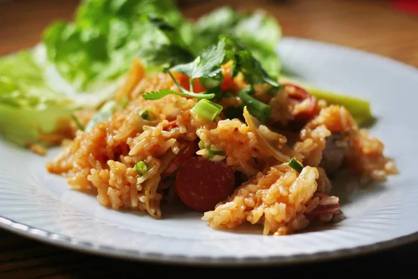 Marul ve kişniş garnitürle servis edilen bir tabakta domuz eti ve kızarmış pilav. Kızarmış pirinç Tayland 'da satılan bir sokak yiyeceğidir..