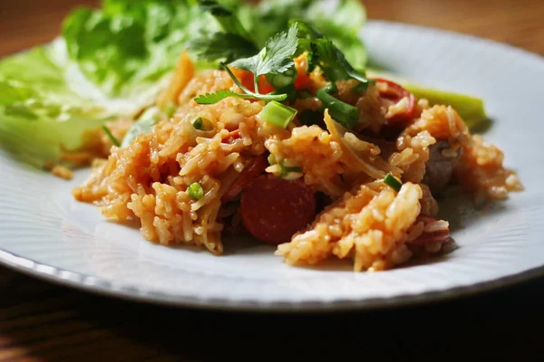 Marul ve kişniş garnitürle servis edilen bir tabakta domuz eti ve kızarmış pilav. Kızarmış pirinç Tayland 'da satılan bir sokak yiyeceğidir..