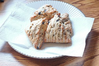 Beyaz tabakta servis edilen böğürtlenli çörekler