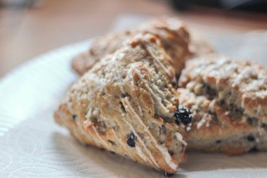 Beyaz tabakta servis edilen böğürtlenli çörekler