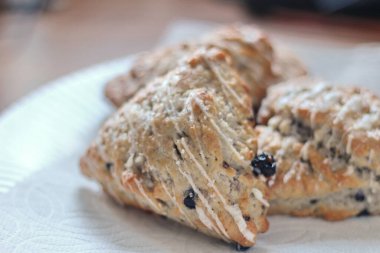 Beyaz tabakta servis edilen böğürtlenli çörekler