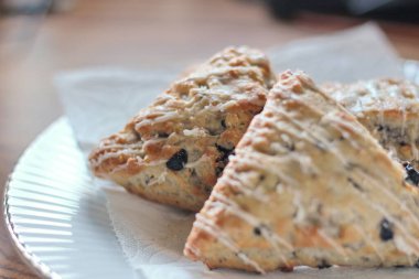 Beyaz tabakta servis edilen böğürtlenli çörekler