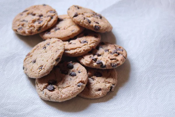 Beyaz kağıda yerleştirilmiş üzümlü kurabiyeler.