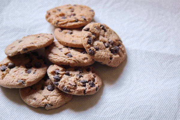 Beyaz kağıda yerleştirilmiş üzümlü kurabiyeler.