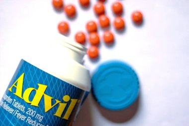 Beyaz bir masaya yayılmış ağrı kesiciler ve haplar. Ateş, ağrı kesici, popüler Amerikan ağrı kesici, ibuprofen..