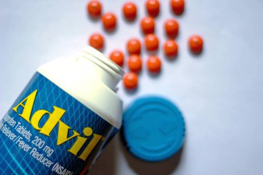 Beyaz bir masaya yayılmış ağrı kesiciler ve haplar. Ateş, ağrı kesici, popüler Amerikan ağrı kesici, ibuprofen..