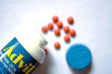 Beyaz bir masaya yayılmış ağrı kesiciler ve haplar. Ateş, ağrı kesici, popüler Amerikan ağrı kesici, ibuprofen..