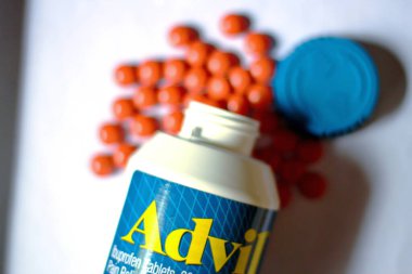 Beyaz bir masaya yayılmış ağrı kesiciler ve haplar. Ateş, ağrı kesici, popüler Amerikan ağrı kesici, ibuprofen..