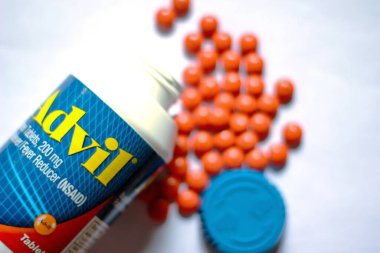 Beyaz bir masaya yayılmış ağrı kesiciler ve haplar. Ateş, ağrı kesici, popüler Amerikan ağrı kesici, ibuprofen..