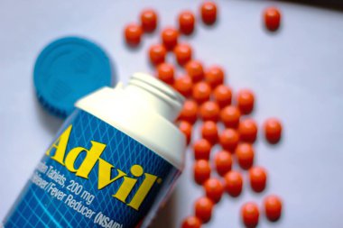 Beyaz bir masaya yayılmış ağrı kesiciler ve haplar. Ateş, ağrı kesici, popüler Amerikan ağrı kesici, ibuprofen..