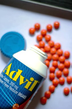 Beyaz bir masaya yayılmış ağrı kesiciler ve haplar. Ateş, ağrı kesici, popüler Amerikan ağrı kesici, ibuprofen..