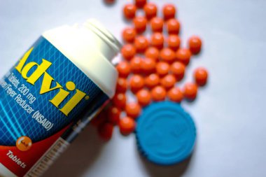 Beyaz bir masaya yayılmış ağrı kesiciler ve haplar. Ateş, ağrı kesici, popüler Amerikan ağrı kesici, ibuprofen..