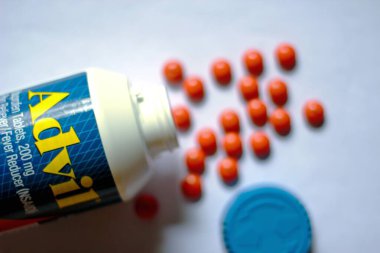 Beyaz bir masaya yayılmış ağrı kesiciler ve haplar. Ateş, ağrı kesici, popüler Amerikan ağrı kesici, ibuprofen..