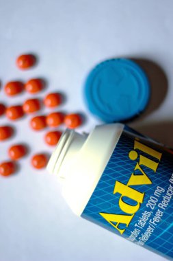 Beyaz bir masaya yayılmış ağrı kesiciler ve haplar. Ateş, ağrı kesici, popüler Amerikan ağrı kesici, ibuprofen..