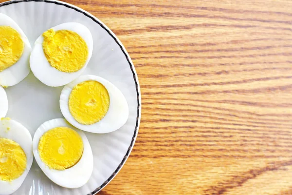 Half boiled eggs laid out in white plates and served on a wooden table.flat lay, Top view.
