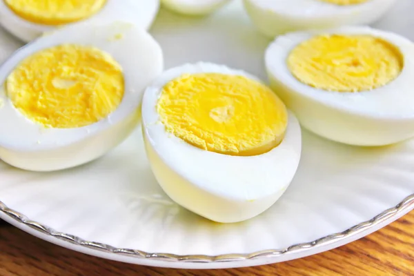 半熟の卵が白い皿に並べられ 木製のテーブルの上で供される — ストック写真