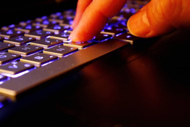 Adam dizüstü bilgisayar kullanıyor, interneti arıyor, bilgileri tarıyor, iş yerinde çalışıyor, yumuşak odaklı resim, klasik konsept, gece