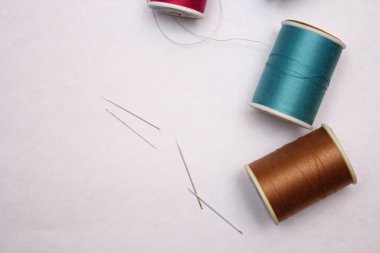 Beyaz zemine yayılmış çok renkli iplikler ve eski makas, retro makas, düz konum, kopyalama alanı.