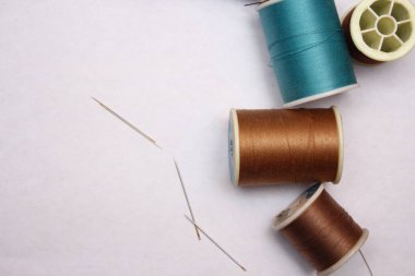 Beyaz zemine yayılmış çok renkli iplikler ve eski makas, retro makas, düz konum, kopyalama alanı.