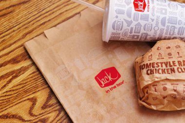 WASHINGTON, ABD - 29 HAZİRAN 2022: ABD 'deki bir kutu restoranda alkolsüz içeceklerle dolu ahşap bir masada ev usulü rance chiken kulüp burgeri.