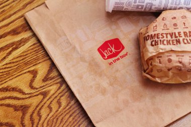 WASHINGTON, ABD - 29 HAZİRAN 2022: ABD 'deki bir kutu restoranda alkolsüz içeceklerle dolu ahşap bir masada ev usulü rance chiken kulüp burgeri.