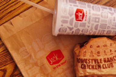 WASHINGTON, ABD - 29 HAZİRAN 2022: ABD 'deki bir kutu restoranda alkolsüz içeceklerle dolu ahşap bir masada ev usulü rance chiken kulüp burgeri.