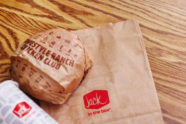 WASHINGTON, ABD - 29 HAZİRAN 2022: ABD 'deki bir kutu restoranda alkolsüz içeceklerle dolu ahşap bir masada ev usulü rance chiken kulüp burgeri.