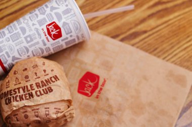 WASHINGTON, ABD - 29 HAZİRAN 2022: ABD 'deki bir kutu restoranda alkolsüz içeceklerle dolu ahşap bir masada ev usulü rance chiken kulüp burgeri.