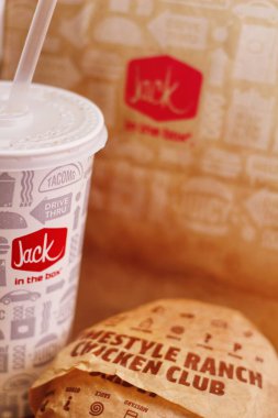 WASHINGTON, ABD - 29 HAZİRAN 2022: ABD 'deki bir kutu restoranda alkolsüz içeceklerle dolu ahşap bir masada ev usulü rance chiken kulüp burgeri.