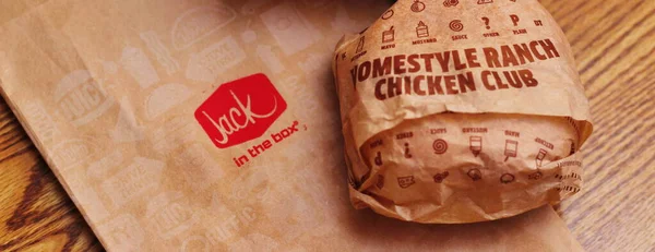 WASHINGTON, ABD - 29 HAZİRAN 2022: ABD 'deki bir kutu restoranda alkolsüz içeceklerle dolu ahşap bir masada ev usulü rance chiken kulüp burgeri.