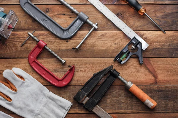 Collection of woodworking tools on a wooden background.