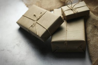 Gift box wrapped in brown recycled paper placed on a white table