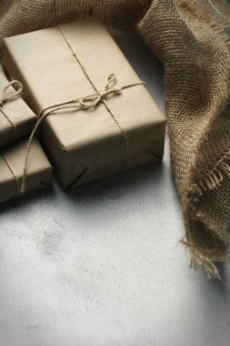 Gift box wrapped in brown recycled paper placed on a white table