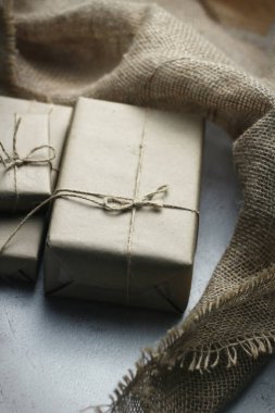 Gift box wrapped in brown recycled paper placed on a white table