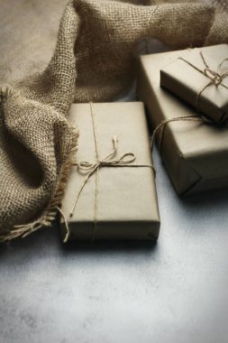 Gift box wrapped in brown recycled paper placed on a white table