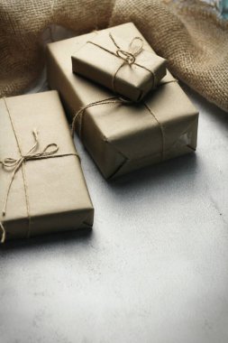 Gift box wrapped in brown recycled paper placed on a white table