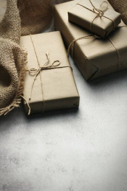 Gift box wrapped in brown recycled paper placed on a white table