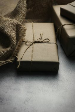 Gift box wrapped in brown recycled paper placed on a white table