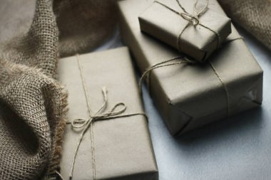 Gift box wrapped in brown recycled paper placed on a white table