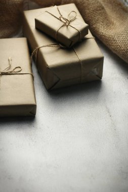 Gift box wrapped in brown recycled paper placed on a white table