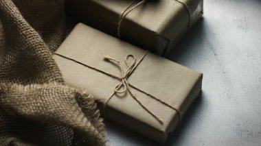 Gift box wrapped in brown recycled paper placed on a white table