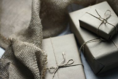 Gift box wrapped in brown recycled paper placed on a white table