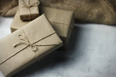 Gift box wrapped in brown recycled paper placed on a white table