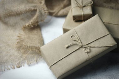 Gift box wrapped in brown recycled paper placed on a white table