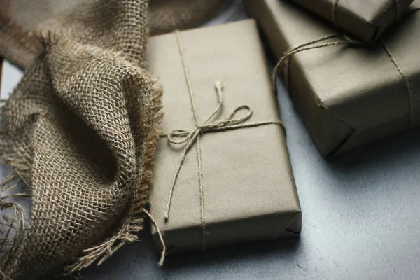 Gift box wrapped in brown recycled paper placed on a white table