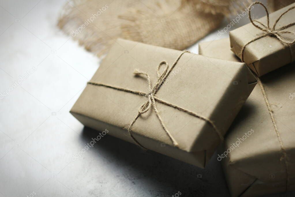 Gift box wrapped in brown recycled paper placed on a white table